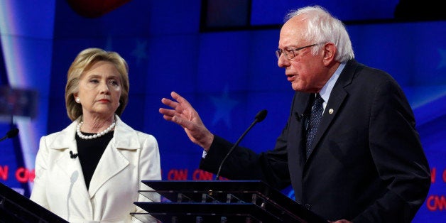 Democratic U.S. presidential candidate Hillary Clinton (L) listens to Senator Bernie Sanders speak during a Democratic debate hosted by CNN and New York One at the Brooklyn Navy Yard in New York April 14, 2016. REUTERS/Lucas Jackson