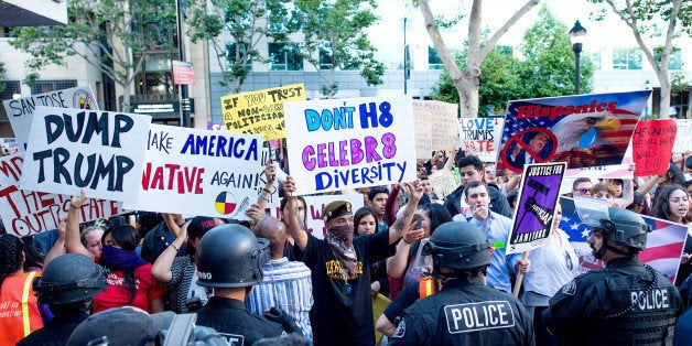 Police form a line to contain protesters outside a campaign rally for Republican presidential candidate Donald Trump on Thurs
