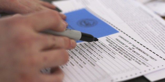 A voter prepares to mark an absentee presidential primary ballot for Bernie Sanders in New Hampshire.