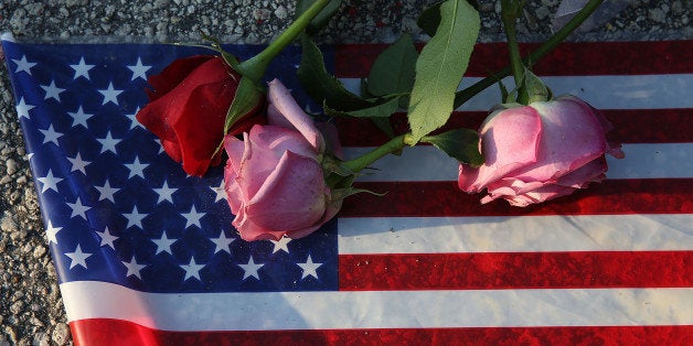 ORLANDO, FL - JUNE 13: Flowers and an American flag are seen on the ground near the Pulse Nightclub where Omar Mateen allegedly killed at least 50 people on June 13, 2016 in Orlando, Florida. The mass shooting killed at least 50 people and injuring 53 others in what is the deadliest mass shooting in the country's history. (Photo by Joe Raedle/Getty Images)