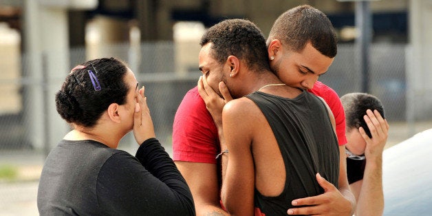 Friends and family members embrace outside the Orlando Police Headquarters during the investigation of a shooting at the Pulse night club, where as many as 20 people have been injured after a gunman opened fire, in Orlando, Florida, U.S June 12, 2016. REUTERS/Steve Nesius TPX IMAGES OF THE DAY