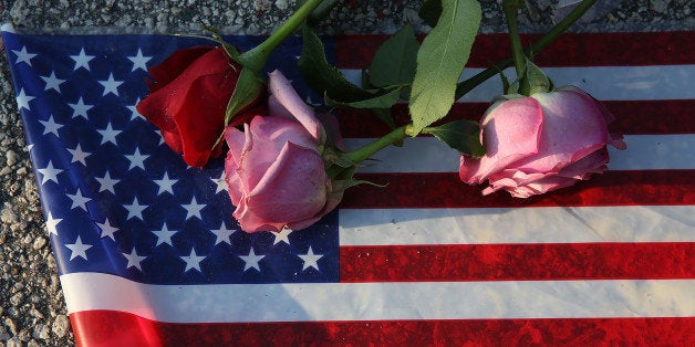 ORLANDO, FL - JUNE 13: Flowers and an American flag are seen on the ground near the Pulse Nightclub where Omar Mateen allege