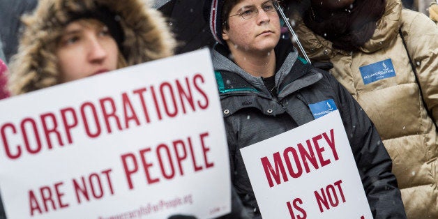 WASHINGTON, DC - JANUARY 21: Attendees hold signs as they listen to speakers during a rally calling for an end to corporate money in politics and to mark the fifth anniversary of the Supreme Court's Citizens United decision, at Lafayette Square near the White House, January 21, 2015 in Washington, DC. Wednesday is the fifth anniversary of the landmark ruling, which paved the way for additional campaign money from corporations, unions and other interests and prevented the government from setting limits on corporate political spending. (Photo by Drew Angerer/Getty Images)