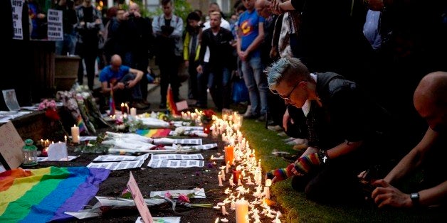 People pay their respects and place candles and tributes at Saint Anne's Church in the Soho district of central London, during a vigil for the victims of Sunday's Orlando shootings at a gay nightclub in Florida, Monday June 13, 2016. Wielding an AR-15 semi-automatic rifle and a handgun, Omar Mateen, a 29-year-old American-born Muslim, opened fire at the crowded Pulse Orlando club early Sunday, killing dozens and wounding others. (AP Photo/Matt Dunham)