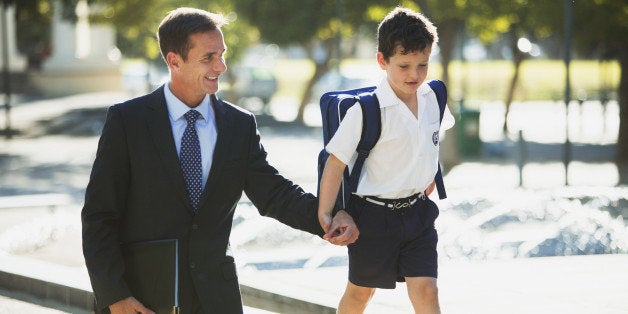 Businessman and son holding hands in urban park