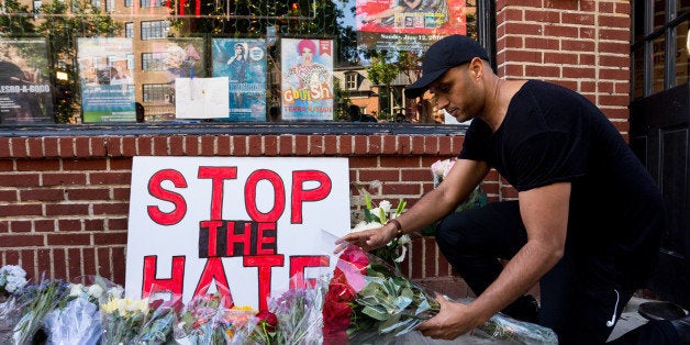 STONEWALL INN, MANHATTAN, NEW YORK, NY, UNITED STATES - 2016/06/12: An attendee of the rally places a bouquet of flowers at a