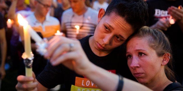 FILE - In this Monday, June 13, 2016 file photo, Jennifer, right, and Mary Ware light candles during a vigil in Orlando, Fla.
