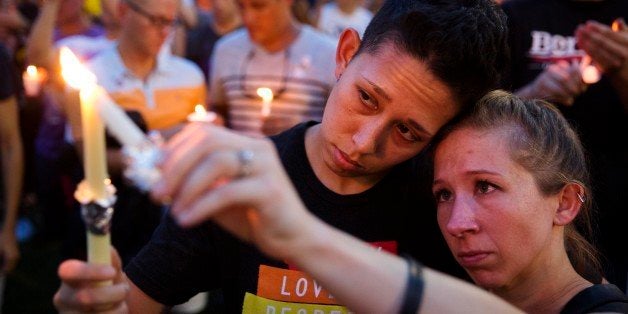 FILE - In this Monday, June 13, 2016 file photo, Jennifer, right, and Mary Ware light candles during a vigil in Orlando, Fla., for the victims of the mass shooting at the Pulse nightclub. On Sunday, June 12, 2016 a gunman killed dozens at the crowded gay nightclub, making it the deadliest mass shooting in modern U.S. history. (AP Photo/David Goldman)