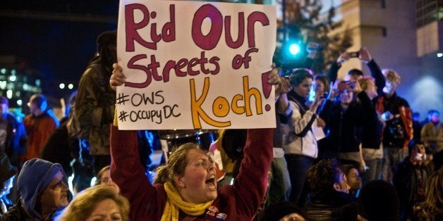 Protesters from Occupy DC block a street in front of the Washington Convention Center during a demonstration against the billionaire conservative donor Koch brothers and Americans for Prosperity, on November 4, 2011 in Washington, DC. Americans for Prosperity, founded by the Koch brothers, a conservative political advocacy group opposing government regulation, is holding its fifth annual meeting at the Convention Center. AFP PHOTO/Nicholas KAMM (Photo credit should read NICHOLAS KAMM/AFP/Getty Images)