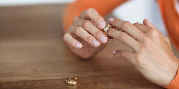 Mid adult woman toying with gold wedding ring on finger