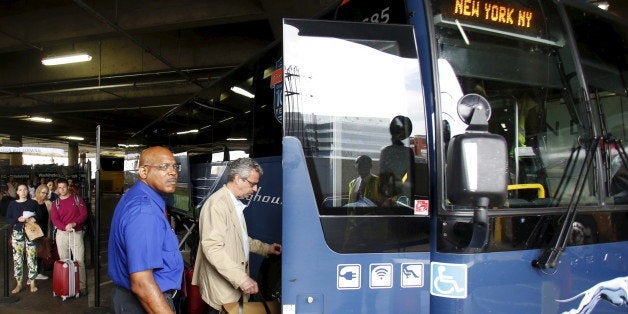 Commuters board Greyhound bus en route to New York City, at the Union Station in Washington May 13, 2015. Rescue workers on Wednesday searched through twisted metal and debris after an Amtrak train derailed in Philadelphia, while investigators sought the cause of the accident that killed at least six people and injured scores of others. The derailment left travelers along the busy Washington-to-New York corridor scrambling for alternatives. REUTERS/Yuri Gripas