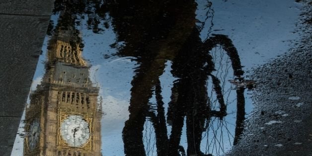 The Queen Elizabeth Tower (Big Ben) is reflected in a puddle as a cyclist rides by in London, on 27 June 2016.
Britain began