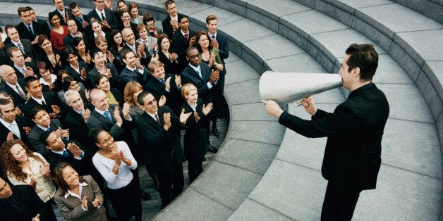 Businessman Standing on Steps Outside Talking Through a Megaphone, Large Group of Business People Listening and Applauding