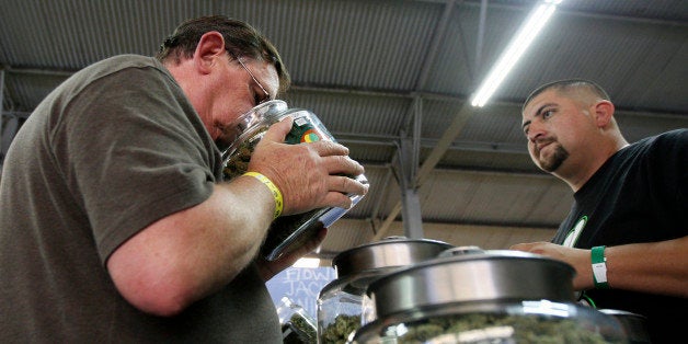 A medical marijuana user smells a jar of marijuana at the medical marijuana farmers market at the California Heritage Market in Los Angeles, California July 11, 2014. REUTERS/David McNew/File Photo