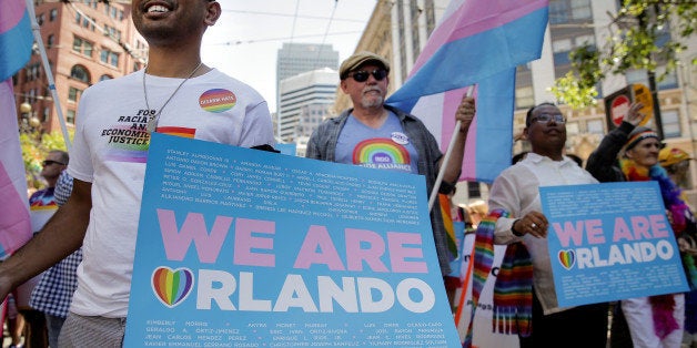 Marchers wave the transgender flag and hold signs memorializing the victims of the Orlando mass shooting at the San Francisco