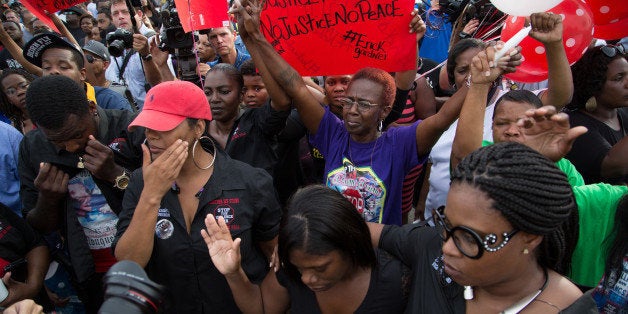 Community members attend a vigil in memory of Alton Sterling, who was shot dead by police, at the Triple S Food Mart in Baton Rouge, Louisiana, U.S. July 6, 2016. REUTERS/Jeffrey Dubinsky