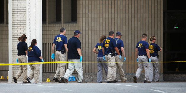 FBI investigators look over the crime scene in Dallas, Texas, U.S. July 8, 2016 following a Thursday night shooting incident that killed five police officers. REUTERS/Carlo Allegri