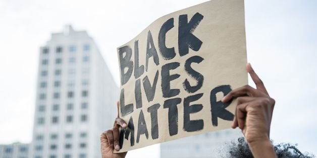 A protestor holds up a sign reading 'Black Lives Matter' during a demonstration in Berlin, on July 10, 2016 with the motto 'B