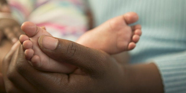 A mother holding her baby daughter's feet.