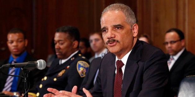 U.S. Attorney General Eric Holder arrives to talk to the media about the shooting of two police officers in Ferguson, and to