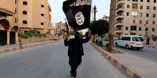 A member loyal to the Islamic State in Iraq and the Levant (ISIL) waves an ISIL flag in Raqqa June 29, 2014. The offshoot of al Qaeda which has captured swathes of territory in Iraq and Syria has declared itself an Islamic "Caliphate" and called on factions worldwide to pledge their allegiance, a statement posted on jihadist websites said on Sunday. The group, previously known as the Islamic State in Iraq and the Levant (ISIL), also known as ISIS, has renamed itself "Islamic State" and proclaimed its leader Abu Bakr al-Baghadi as "Caliph" - the head of the state, the statement said. REUTERS/Stringer (SYRIA - Tags: POLITICS CIVIL UNREST TPX IMAGES OF THE DAY) FOR BEST QUALITY IMAGE ALSO SEE: GF2EAAO0VU501
