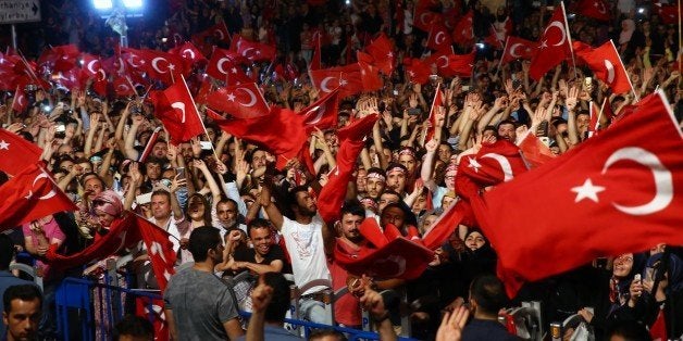 ISTANBUL, TURKEY - JULY 19: People cheer and wave TuTurkish President Recep Tayyip Erdogan addresses the crowd who gathered i