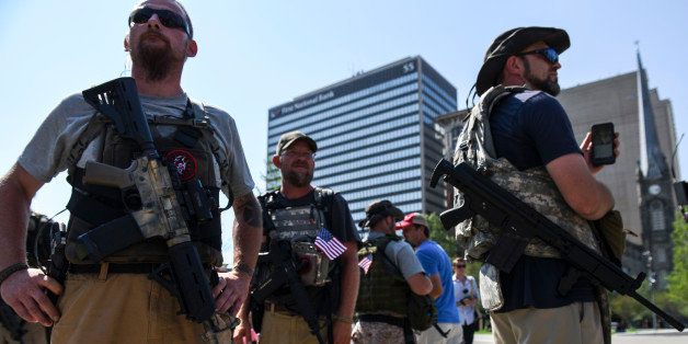 CLEVELAND, OH - JULY 19: Seth Taylor, left, a member of the western Ohio Minutemen, stands in Public Square in downtown Cleveland with his assault rifle on July 19, 2016. Ohio is an 'open carry' state. Protests in the park were peaceful and uneventful. (Photo by Michael Robinson Chavez/The Washington Post via Getty Images)