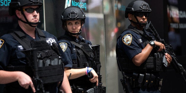 NEW YORK, NY - JULY 15: Members of the New York City Police Department stand guard in Times Square, July 15, 2016 in New York City. Following the terrorist attack in Nice, France, New York governor Andrew Cuomo has directed law enforcement to step up their security presence at high profiles locations around New York City. (Photo by Drew Angerer/Getty Images)