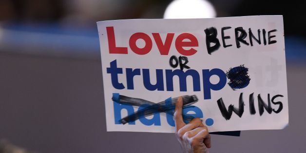 A delegate holds aloft a sign during Day 1 of the Democratic National Convention at the Wells Fargo Center in Philadelphia, Pennsylvania, July 25, 2016. / AFP / Robyn BECK (Photo credit should read ROBYN BECK/AFP/Getty Images)