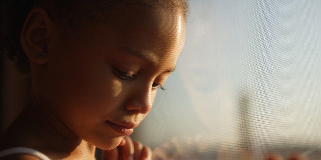 Close up of a little girl looking out a window