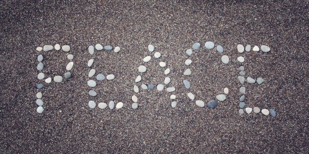 'Peace' word written with pebbles on the sand. Aged photo. 'Peace' word made by small stones on the beach. Word on the sand - toned photo. Antalya Province, Turkey. Wide photo for site slider.