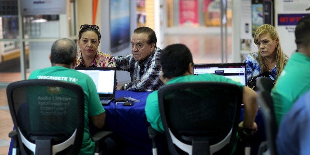 MIAMI, FL - DECEMBER 11: Marlene Gonzalez (L) sits with Alberto Gonzalez (C) as they and Marinely Perez (R) speak with insurance agents with Sunshine Life and Health Advisors about purchasing insurance under the Affordable Care Act at a kiosk setup at the Mall of Americas on December 11, 2013 in Miami, Florida. As Health and Human Services Secretary Kathleen Sebelius tesified in Washington, DC before a congressional panel that the Affordable Care Act website was improving, the Sunshine Life and Health Advisors said, that they are starting to see a steady increase in the numbers of people coming to them to purchase and understand the policies offered under the Affordable Care Act. (Photo by Joe Raedle/Getty Images)