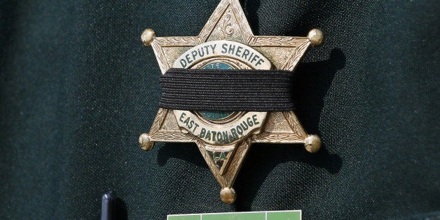 A Baton Rouge Sheriffâs Deputy badge is seen with a black band before the funeral of Deputy Brad Garafola at Istrouma Bapti