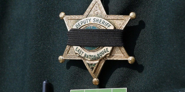 A Baton Rouge Sheriffâs Deputy badge is seen with a black band before the funeral of Deputy Brad Garafola at Istrouma Baptist Church in Baton Rouge, Louisiana, U.S. July 23, 2016. REUTERS/Jonathan Bachman