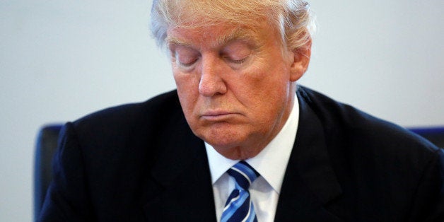 Republican presidential nominee Donald Trump reads a document during a round table discussion on security at Trump Tower in the Manhattan borough of New York, U.S., August 17, 2016. REUTERS/Carlo Allegri