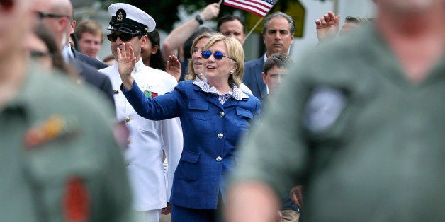 Democratic presidential candidate Hillary Clinton waves as she walks behind marching veterans in a Memorial Day parade Monday, May 30, 2016, in Chappaqua, N.Y. (AP Photo/Mel Evans)