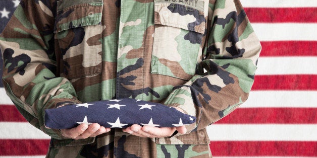 US Army soldier holding country flag by Stars and Stripes