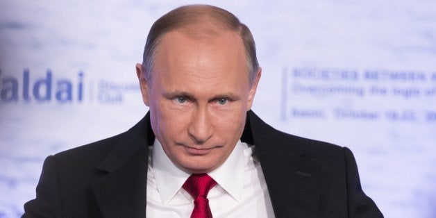 Russian President Vladimir Putin adjusts his jacket as he attends a meeting of members of the Valdai International Discussion Club in Sochi on October 22, 2015. President Vladimir Putin on October 22 accused the West of playing a 'double game' with terrorist groups in Syria, where a US-led coalition has conducted a bombing campaign with its allies. AFP PHOTO / POOL / ALEXANDER ZEMLIANICHENKO (Photo credit should read ALEXANDER ZEMLIANICHENKO/AFP/Getty Images)