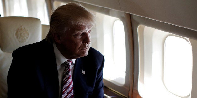 Republican presidential nominee Donald Trump looks out the window as he travels aboard his plane between campaign stops in Ohio, U.S. September 5, 2016. REUTERS/Mike Segar