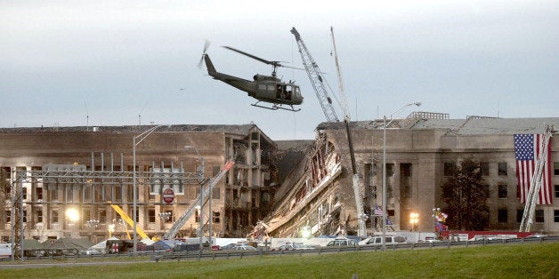 ARLINGTON, VA - SEPTEMBER 14, 2001: (SEPTEMBER 11 RETROSPECTIVE) A military helicopter flies in front of the Pentagon September 14, 2001 in Arlington, Virginia at the impact site where a hijacked airliner crashed into the building. (Photo by Stephen J. Boitano/Getty Images)