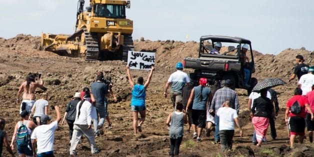 Native American protestors and their supporters are confronted by security during a demonstration against work being done for the Dakota Access Pipeline (DAPL) oil pipeline, near Cannon Ball, North Dakota, September 3, 2016. / AFP / Robyn BECK / TO GO WITH AFP STORY by Nova SAFO, 'Native Americans united by oil pipeline fight' (Photo credit should read ROBYN BECK/AFP/Getty Images)
