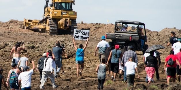 Native American protestors and their supporters are confronted by security during a demonstration against work being done for the Dakota Access Pipeline (DAPL) oil pipeline, near Cannon Ball, North Dakota, September 3, 2016. / AFP / Robyn BECK / TO GO WITH AFP STORY by Nova SAFO, 'Native Americans united by oil pipeline fight' (Photo credit should read ROBYN BECK/AFP/Getty Images)