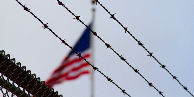 An American flag behind a barbwire fence. May symbolize prison, political messages, or loss of freedom.