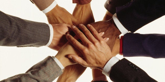 Hands of businesspeople in huddle