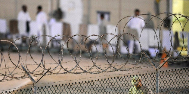 A Navy guard patrols Camp Delta?s detainee recreation yard during the early morning at Guantanamo Bay naval base in a July 7,