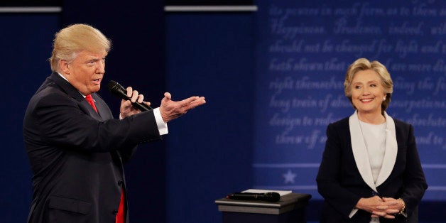 Republican presidential nominee Donald Trump speaks with Democratic presidential nominee Hillary Clinton during the second presidential debate at Washington University in St. Louis, Sunday, Oct. 9, 2016. (AP Photo/John Locher)