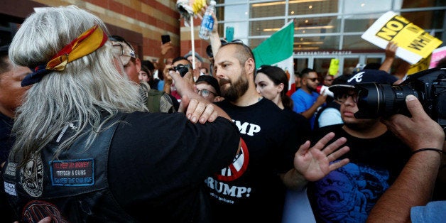 A man faces off with protesters during a rally against U.S. Republican Presidential candidate Donald Trump, who is in town to speak on immigration, in Phoenix, Arizona, U.S. August 31, 2016. REUTERS/Nancy Wiechec