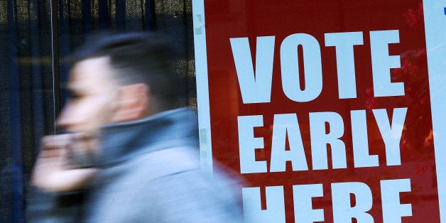 A pedestrian walks past a polling station during early voting in Chicago, Illinois, U.S., October 14, 2016. REUTERS/Jim Young