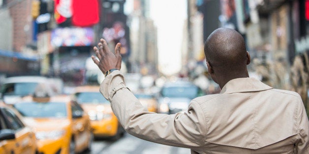 Black businessman hailing taxi on city street