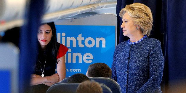 U.S. Democratic presidential nominee Hillary Clinton talks to staff members, including aide Huma Abedin (L), onboard her campaign plane in White Plains, New York, U.S. October 28, 2016. REUTERS/Brian Snyder TPX IMAGES OF THE DAY 
